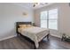 Cozy bedroom with a queen-size bed, neutral decor, and a large window overlooking the backyard, offering natural light at 115 Westbury Ln, Johns Creek, GA 30005