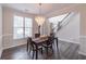 Elegant dining room features a crystal chandelier, hardwood floors, and wainscoting at 115 Westbury Ln, Johns Creek, GA 30005