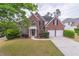 Charming two-story brick home with a manicured lawn and convenient two-car garage at 115 Westbury Ln, Johns Creek, GA 30005