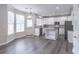 Bright eat-in kitchen boasts white cabinets, stainless steel appliances, and granite countertops, island, and backyard access at 115 Westbury Ln, Johns Creek, GA 30005