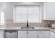 Kitchen sink, window, and countertops with white cabinets, tile backsplash and stainless steel appliances at 115 Westbury Ln, Johns Creek, GA 30005