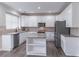 Modern kitchen with white cabinets, stainless steel appliances, tile backsplash and central island with dark wood floors at 115 Westbury Ln, Johns Creek, GA 30005