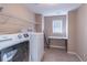 Efficient laundry room with washer, dryer, shelving, and a folding table at 115 Westbury Ln, Johns Creek, GA 30005