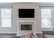 Living room fireplace with white mantle and hearth, flanked by window seats, and dark wood floors at 115 Westbury Ln, Johns Creek, GA 30005