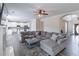 Open living room with modern kitchen, gray sectional sofa, and an inviting fireplace at 115 Westbury Ln, Johns Creek, GA 30005