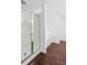 Modern bathroom featuring a glass-enclosed shower and dark wood-look flooring at 2539 Larson Creek Cove, Duluth, GA 30097