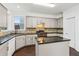 Bright kitchen features shaker style cabinets, dark countertops, tile backsplash and kitchen island at 2539 Larson Creek Cove, Duluth, GA 30097