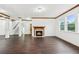 Spacious living room featuring dark hardwood floors, bright natural light, and a fireplace with wooden mantle at 2539 Larson Creek Cove, Duluth, GA 30097