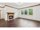 Bright living room features a fireplace with wood mantle, hardwood floors, and large windows overlooking a green yard at 2539 Larson Creek Cove, Duluth, GA 30097