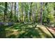 Landscaped backyard featuring a small play set, shade trees, and a retaining wall with adirondack chairs at 3046 Valley Cir, Decatur, GA 30033