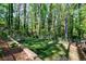 Private backyard features a play set, shade trees, lush greenery, and a terraced retaining wall at 3046 Valley Cir, Decatur, GA 30033