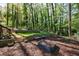 Backyard with stone retaining wall, bench, planting boxes, swing set, and wooded view at 3046 Valley Cir, Decatur, GA 30033
