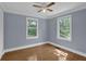 Sunlit bedroom with hardwood floors, trim, and views from two large windows at 5942 Morgan Rd, Atlanta, GA 30340