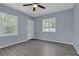Bedroom featuring wood-look flooring, natural light from two windows, and an exterior access door at 5942 Morgan Rd, Atlanta, GA 30340