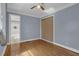 Bright bedroom featuring hardwood floors, a ceiling fan, closet, and an ensuite bathroom at 5942 Morgan Rd, Atlanta, GA 30340