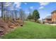 Sloping backyard featuring lush lawn and hillside foliage at 5945 Boulder Bluff Dr, Cumming, GA 30040