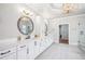 Bright bathroom with double vanity, white cabinets, marble countertops, and a modern, gold light fixture at 5945 Boulder Bluff Dr, Cumming, GA 30040