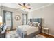 Comfortable bedroom with a gray upholstered bed, ceiling fan, and two windows with blue curtains at 5945 Boulder Bluff Dr, Cumming, GA 30040