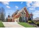 Stunning brick home featuring a stone accent, attached garage, well manicured lawn, and a concrete driveway at 5945 Boulder Bluff Dr, Cumming, GA 30040
