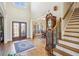 Grand foyer with a wooden staircase, ornate front door, hardwood floors, and area rug at 5945 Boulder Bluff Dr, Cumming, GA 30040