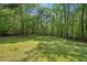 Lush, green backyard with mature trees providing ample shade, perfect for outdoor activities at 8540 Ridge Rd, Fairburn, GA 30213