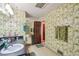 This bathroom has a single sink vanity, shower-tub combo, and a unique bamboo wallpaper at 8540 Ridge Rd, Fairburn, GA 30213