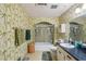 This bathroom has a single sink vanity, shower-tub combo, and unique bamboo wallpaper at 8540 Ridge Rd, Fairburn, GA 30213