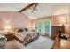 Bedroom featuring exposed beam, neutral carpeting, floral bedding, and natural light at 8540 Ridge Rd, Fairburn, GA 30213