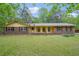 Charming brick home with a classic ranch-style design and mature trees in the landscaped front yard at 8540 Ridge Rd, Fairburn, GA 30213