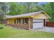View of the home's brick exterior with a two-car garage, providing convenience and extra storage at 8540 Ridge Rd, Fairburn, GA 30213