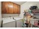 Laundry room with washer, dryer, wooden cabinets, and shelving for storage at 8540 Ridge Rd, Fairburn, GA 30213