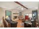 Cozy living room featuring hardwood floors, exposed beams, a brick fireplace, and comfortable seating at 8540 Ridge Rd, Fairburn, GA 30213