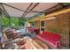 Inviting covered patio with brick accent wall, seating, and view of the outdoor pool at 8540 Ridge Rd, Fairburn, GA 30213