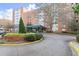 Exterior view of a brick apartment building with a circular driveway and landscaped entrance at 2965 Pharr Court South Nw # 304, Atlanta, GA 30305