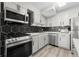 Modern kitchen features stainless steel appliances, light gray cabinets and a black hexagon tile backsplash at 2965 Pharr Court South Nw # 304, Atlanta, GA 30305