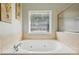 A luxurious bathroom with a tiled corner bathtub and windows for natural light at 3070 Glad Dale Se Dr, Conyers, GA 30094