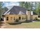 Rear exterior view of a tan home with a dark roof, showing multiple windows and a chimney at 3070 Glad Dale Se Dr, Conyers, GA 30094