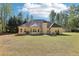 Rear exterior view of a tan home with a dark roof, showing multiple windows and a chimney at 3070 Glad Dale Se Dr, Conyers, GA 30094