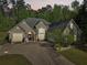 Beautiful home with mature trees, landscaping, and a large driveway at 3070 Glad Dale Se Dr, Conyers, GA 30094
