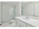 Bright bathroom featuring a glass shower, white vanity with modern finishes, and clean, minimalist design elements at 5816 Creek Indian Dr, Sugar Hill, GA 30518