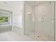 Spa-like bathroom featuring a glass-enclosed shower, soaking tub, and stylish tile flooring at 5816 Creek Indian Dr, Sugar Hill, GA 30518