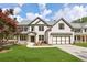 Charming two-story home featuring a brick facade, gabled roof, manicured lawn, and a spacious two-car garage at 5816 Creek Indian Dr, Sugar Hill, GA 30518