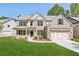 Beautiful new construction home featuring a brick and siding exterior, lush lawn, and a two-car garage at 5816 Creek Indian Dr, Sugar Hill, GA 30518