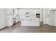 Modern kitchen with white cabinets, stainless steel appliances, a kitchen island and hardwood floors at 5816 Creek Indian Dr, Sugar Hill, GA 30518