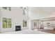Spacious living room with high ceilings, a fireplace, and an adjacent kitchen, offering an open layout at 5816 Creek Indian Dr, Sugar Hill, GA 30518