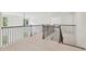 Open loft area with elegant dark wood railings and natural light streaming in through the windows at 5816 Creek Indian Dr, Sugar Hill, GA 30518