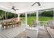 This covered patio features ceiling fans and a dining table with chairs, overlooking the backyard at 110 White Oak Trl, Cumming, GA 30028