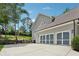 Three car garage exterior with a paved driveway, manicured lawn, and some shrubbery at 110 White Oak Trl, Cumming, GA 30028