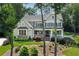 Beautiful two-story home with a covered porch, manicured landscaping, and mature trees at 110 White Oak Trl, Cumming, GA 30028