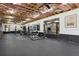Spacious gym featuring exposed wood ceiling, ample equipment, large mirrors and an entertainment center at 110 White Oak Trl, Cumming, GA 30028